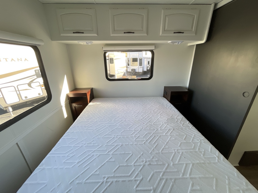 Rear queen bedroom with comfortable mattress and built-in storage