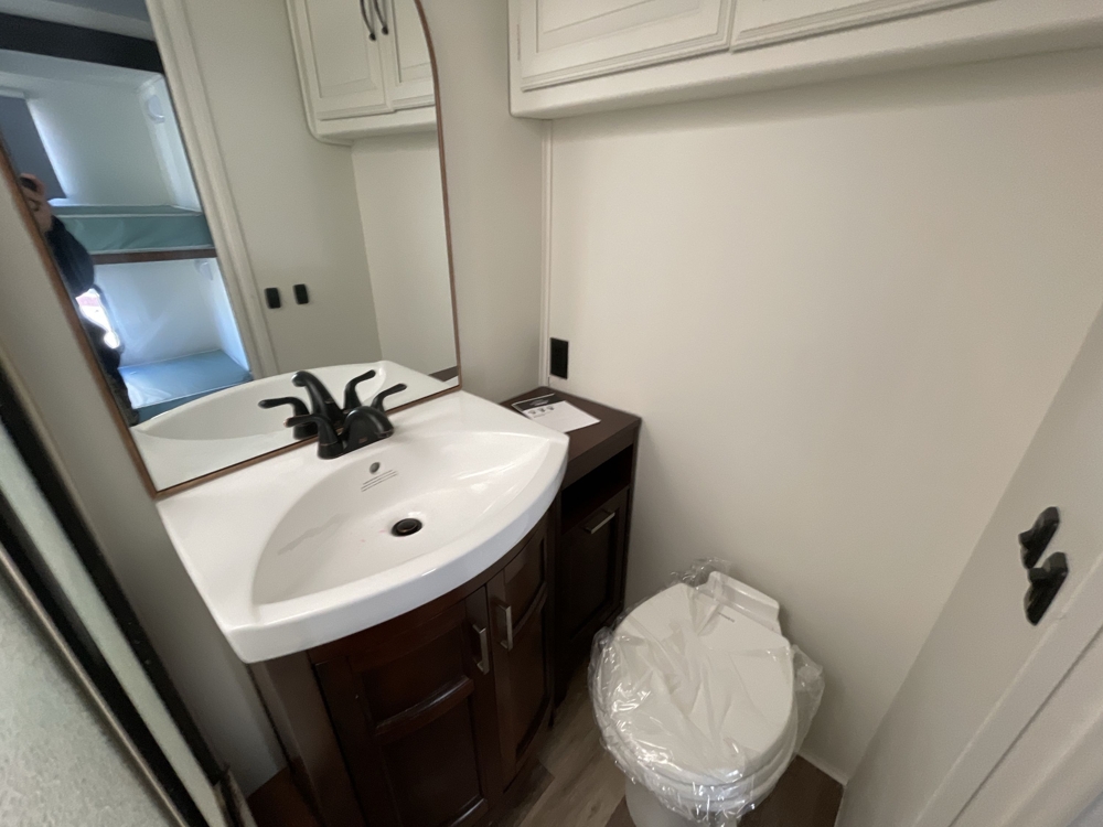 Full bathroom with vanity sink, dark wood cabinetry, and toilet