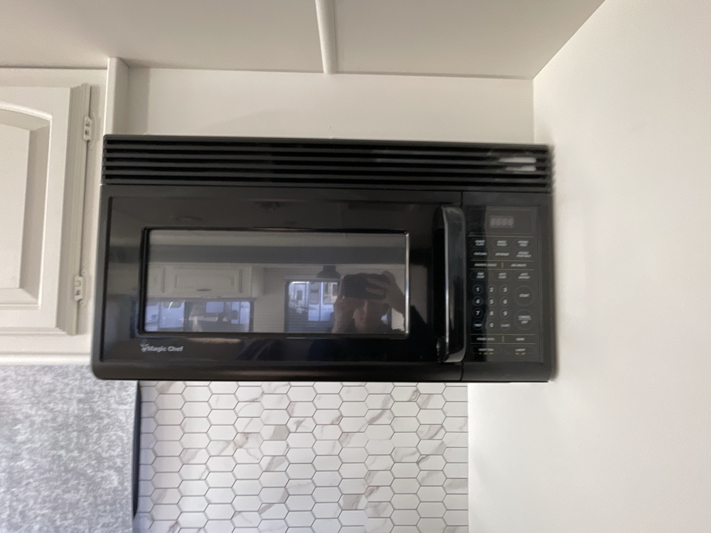 Built-in Magic Chef microwave mounted above hexagonal tile backsplash