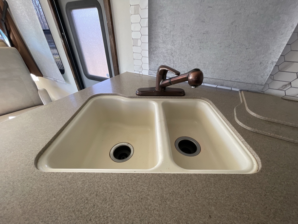 Kitchen area with double basin sink and granite countertops