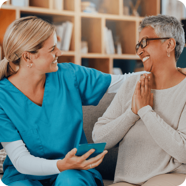 Healthcare provider in turquoise scrubs having a compassionate moment with patient in a warm clinical setting