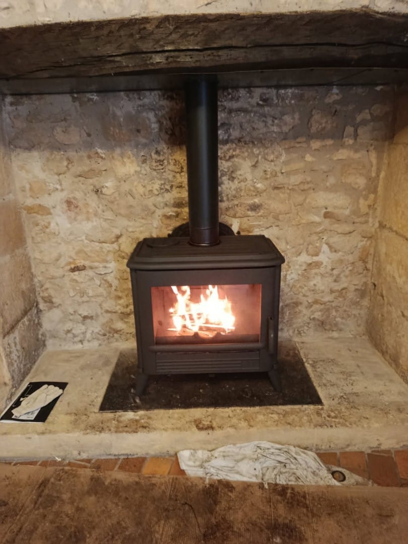 Poêle à bois dans cheminée en pierre