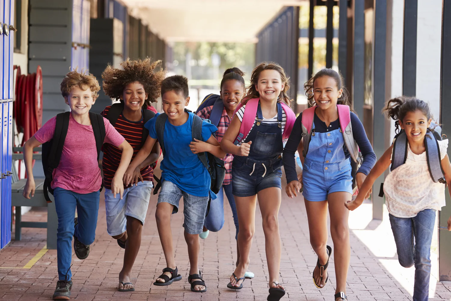 Happy students running together in a school hallway, demonstrating student-led active engagement