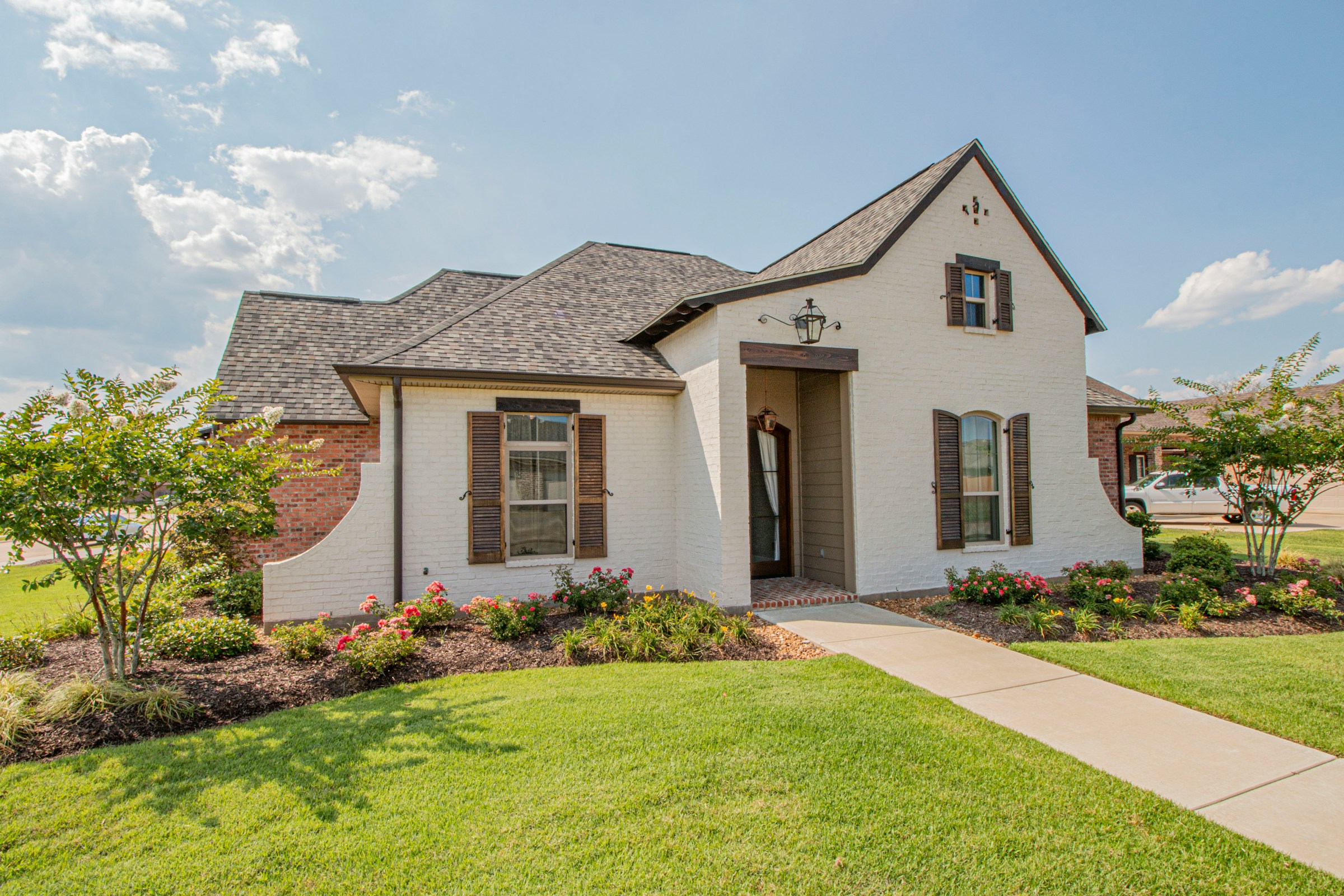 Beautiful white painted brick home with gray asphalt shingle roof in Abilene TX