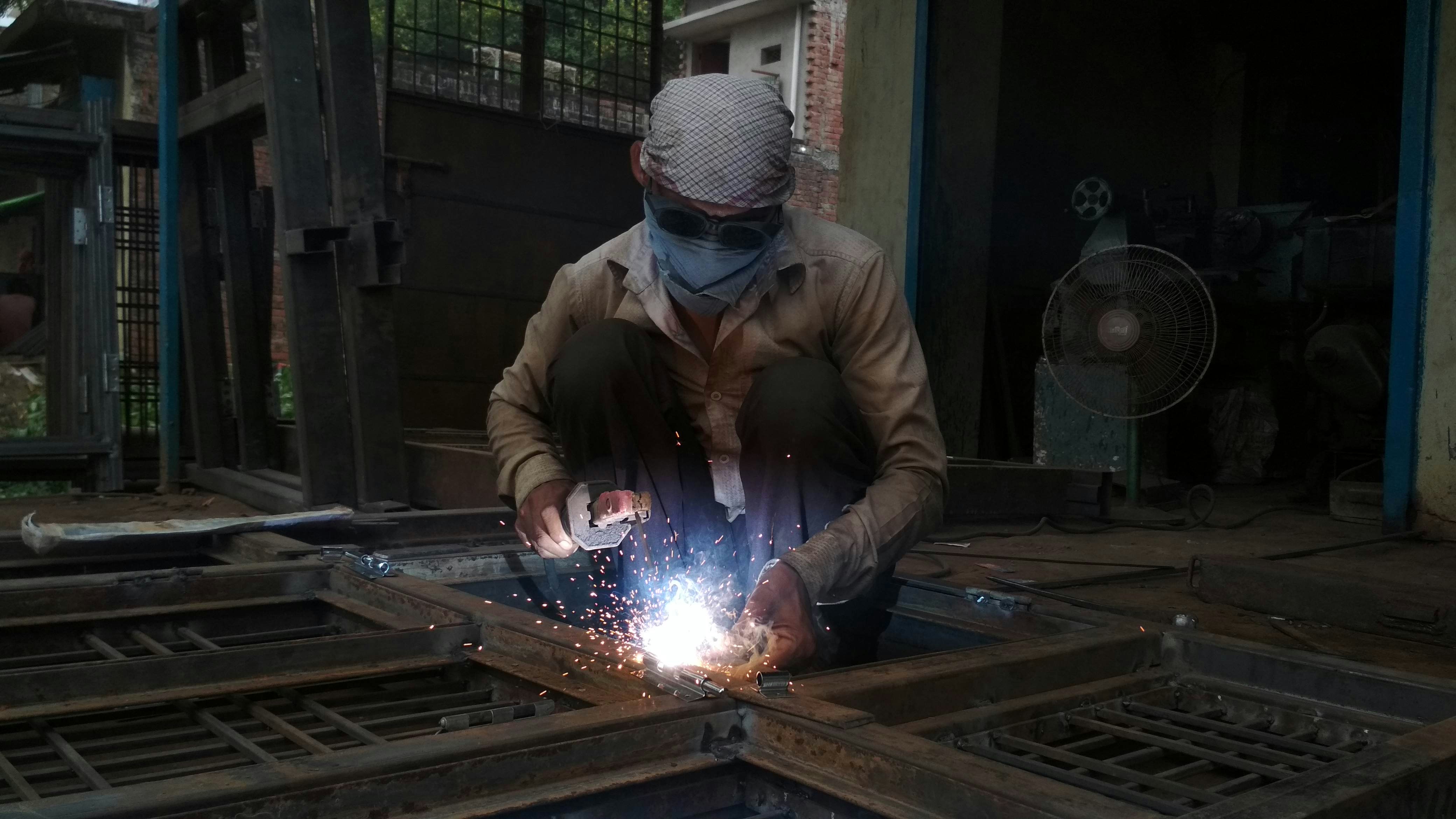 Skilled tradesperson welding metal with sparks flying