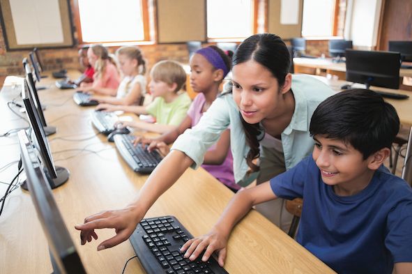 Teacher helping student with computer learning