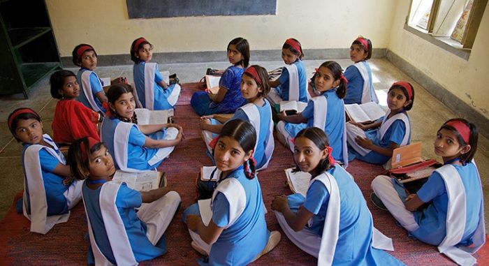 Students in blue uniforms engaged in classroom learning