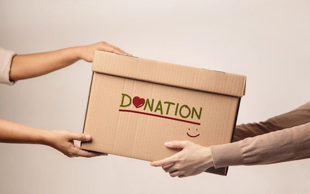 Hands passing a donation box with heart symbol, representing charitable giving