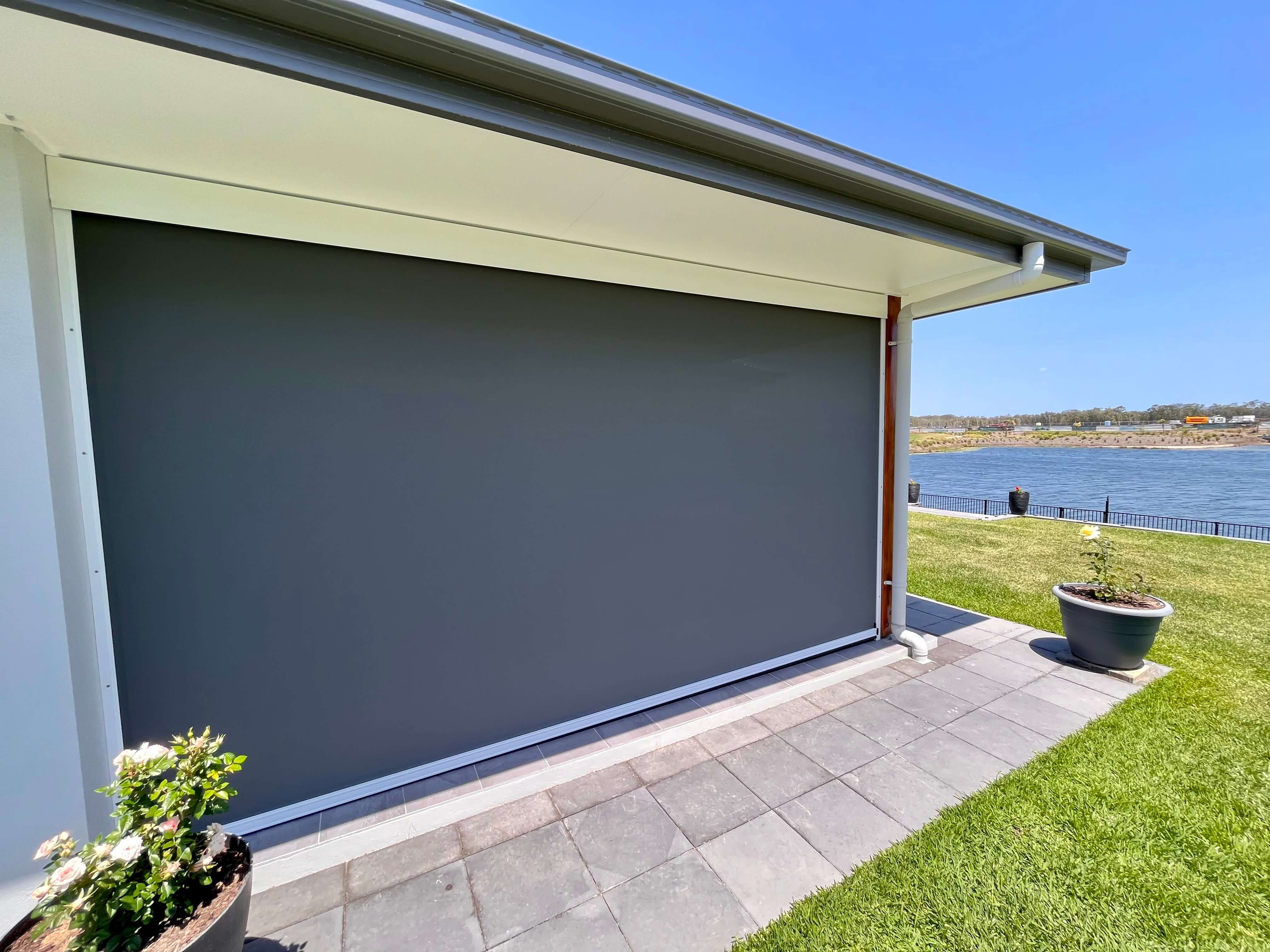 Roof to fence blind fully extended on waterfront home