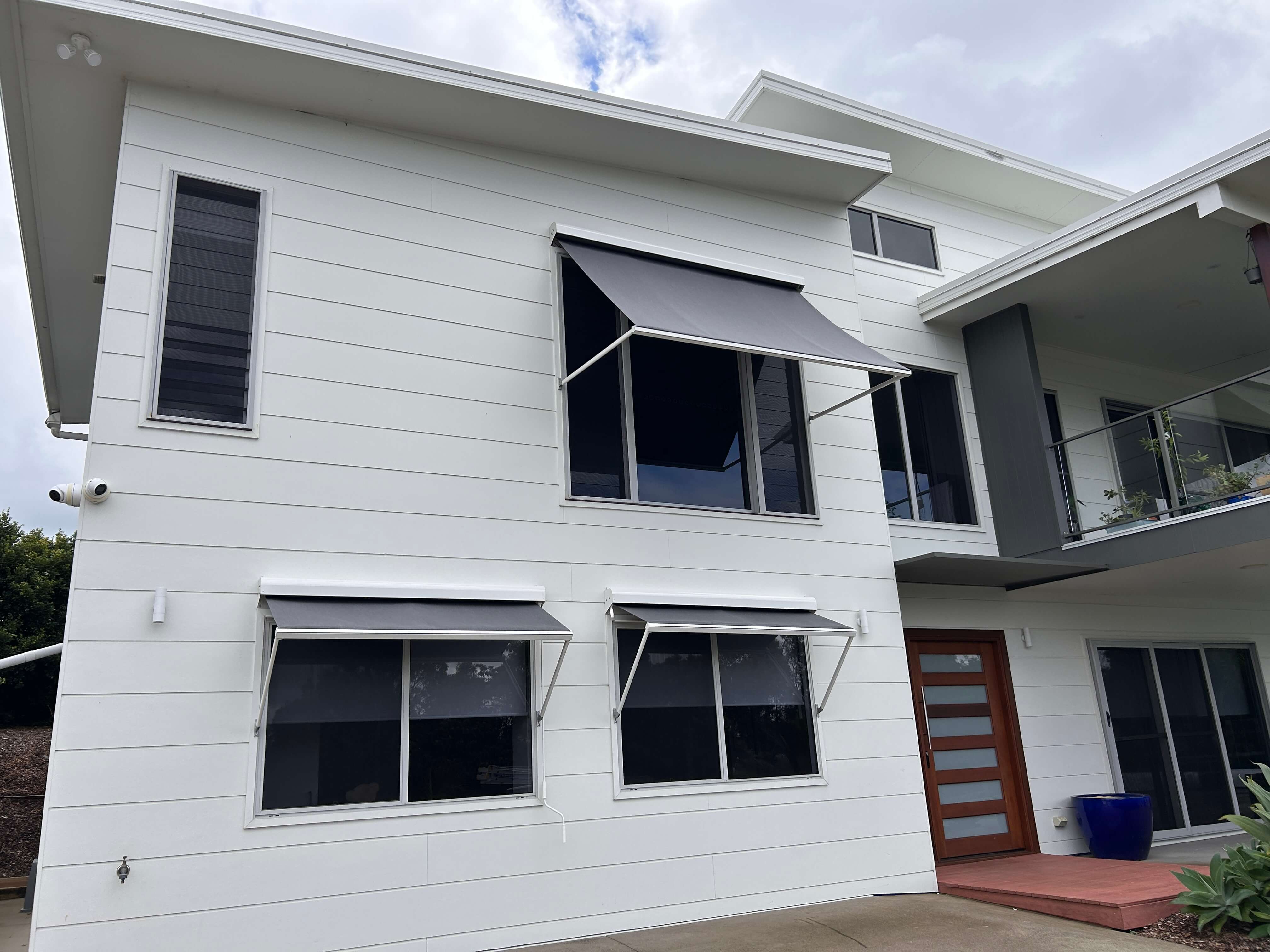 Pivot arm awning on modern home
